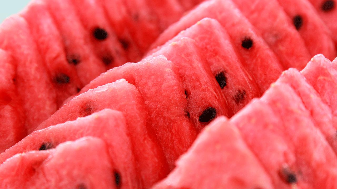 Rækker af røde vandmeloner med sorte kerner.  