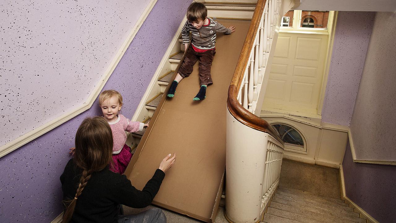Børn på papkasse på trappe