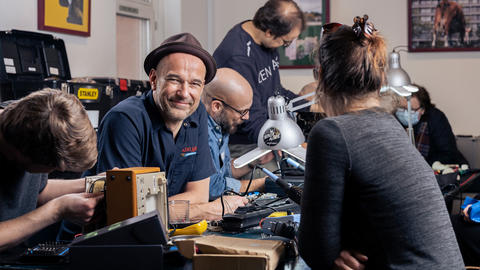 Frivillige på en Repair Café reparerer gammelt elektronikudstyr 