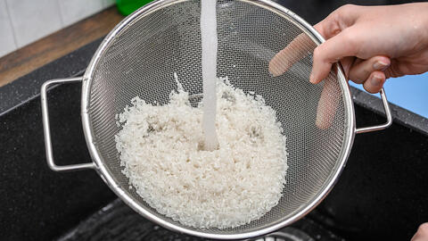 Ris bliver skyllet i si over vask