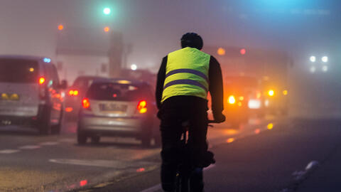 Cyklist bagfra med refleksvest på i tåget by