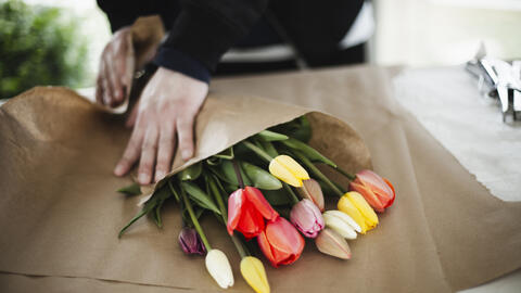 Et bundt tulipaner bliver pakket ind