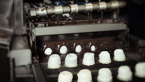 Flødeboller bliver overtrukket med chokolade