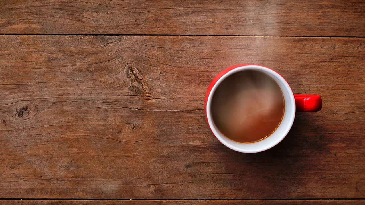 Filterkaffe i rød kop på træbord
