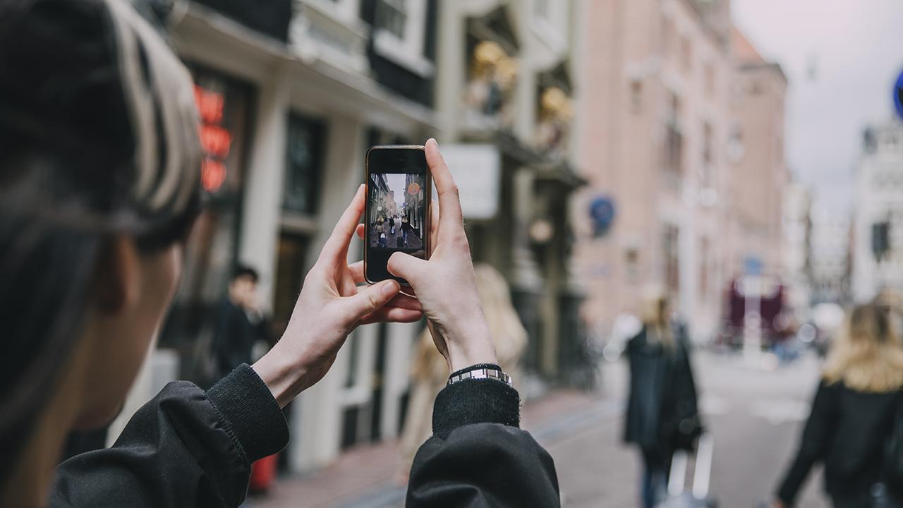 Kvinde der tager billeder af folk på gaden