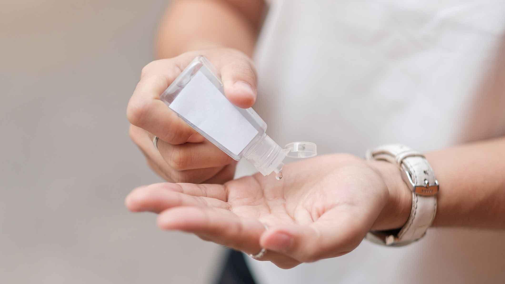 En person tager håndsprit i håndfladen fra en lille plastikflaske