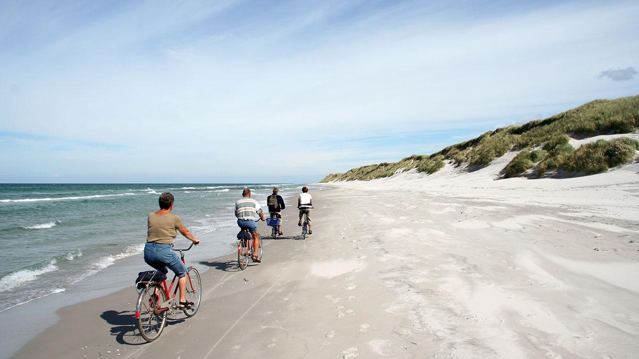 Mennesker cykler på stranden