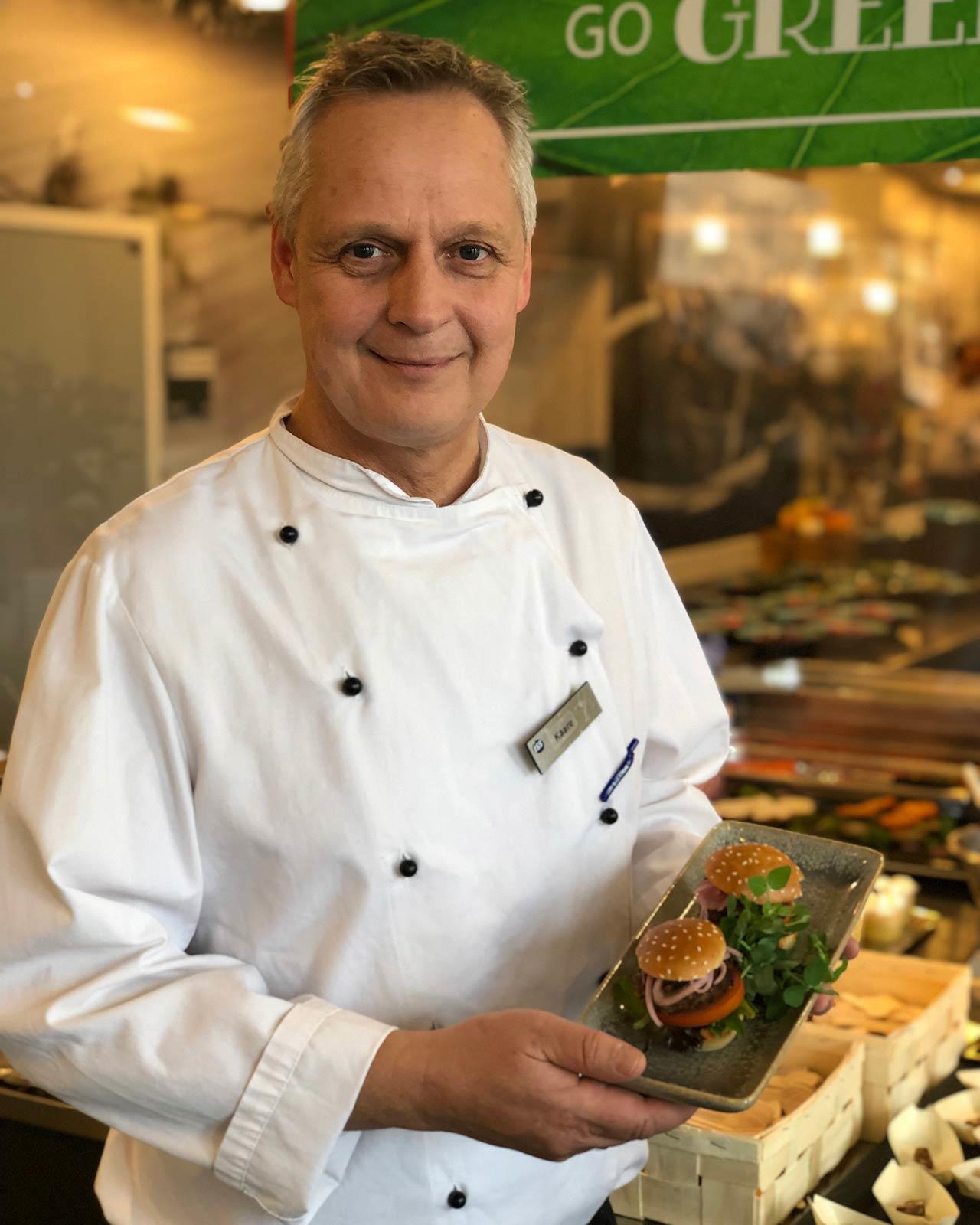 Køkkenchef Kaare Nielsen fra Danske Banks kantine praesenterer burgere med insektkoedet fra Hey Planet.