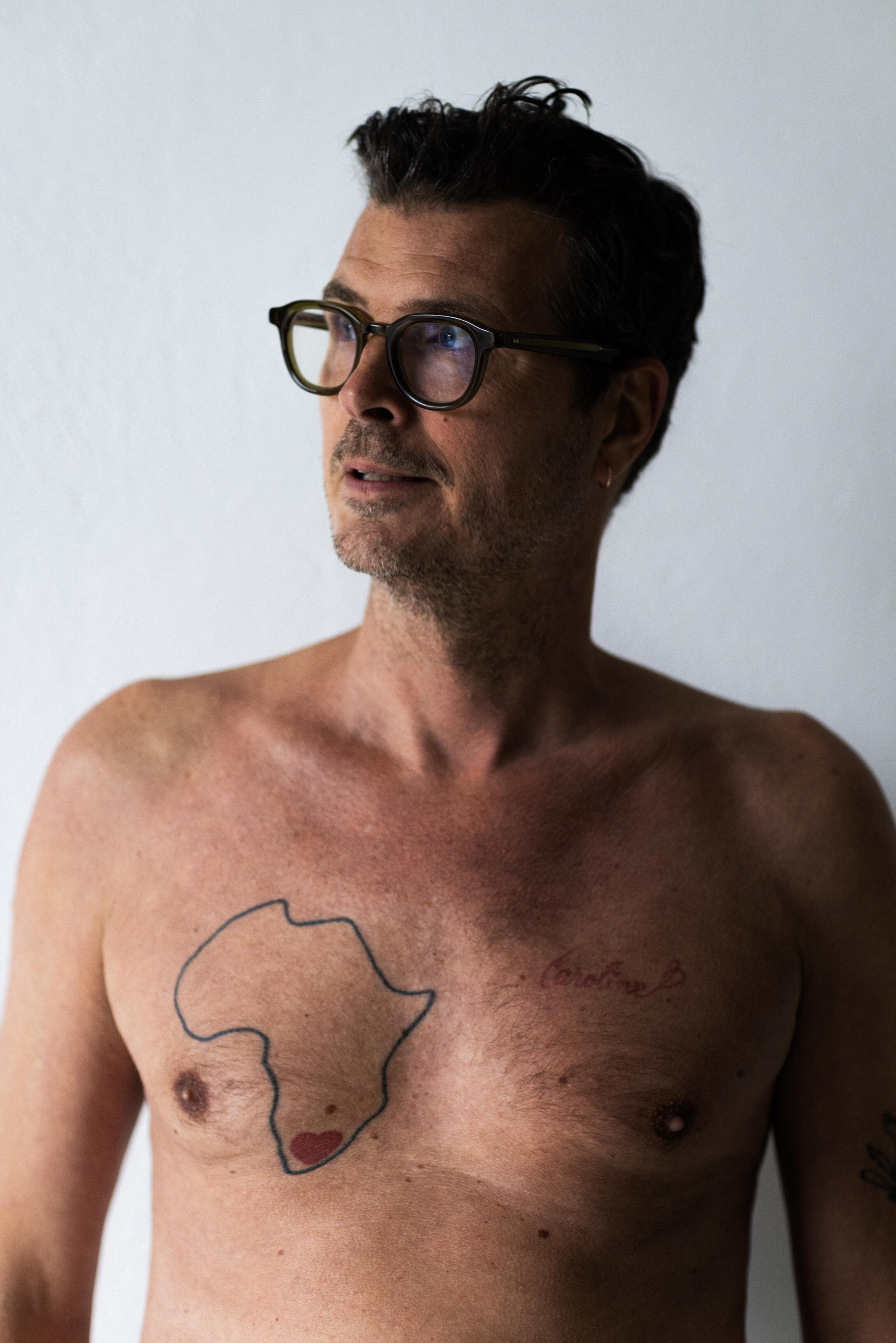 Pelle Hvenegaard med tatovering af det afrikanske kontinent og et lille rødt hjerte på sit bryst