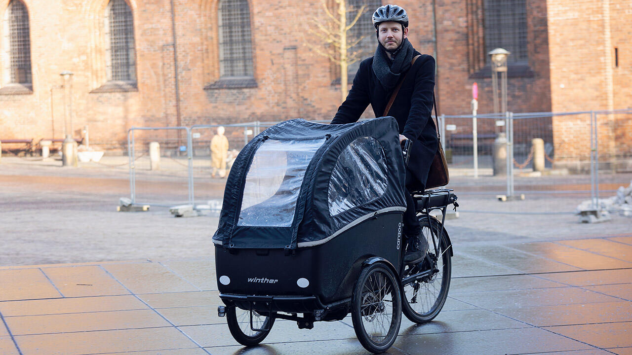 Cyklist med ladcykel foran kirke