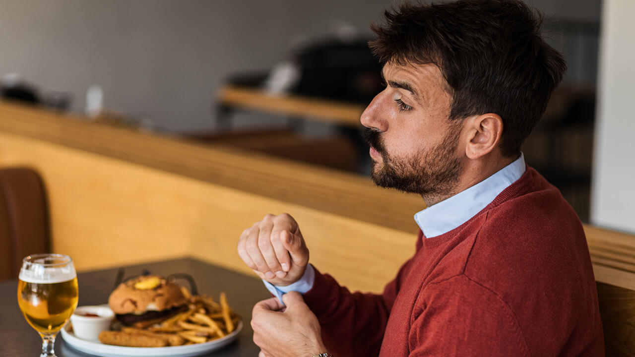 mand spiser burger og pomfritter 