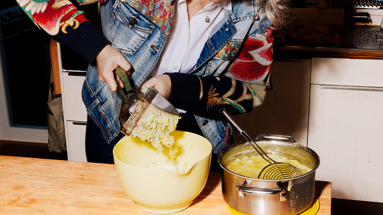 Benedikte presser kartoffelmos med kartoffelpresseren.