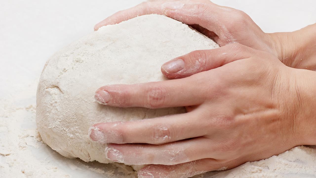 To hænder holder om en brøddej