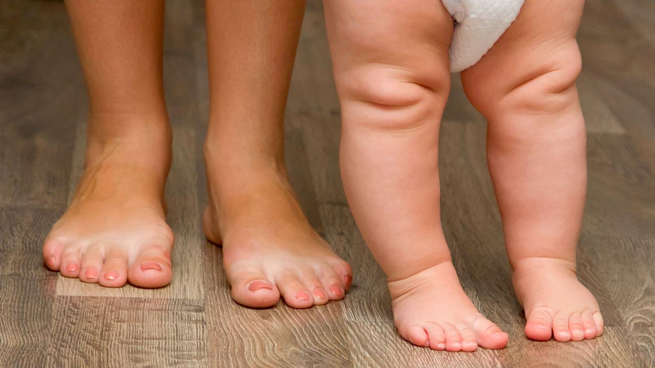 Et par voksne fødder og et par barnefødder side om side