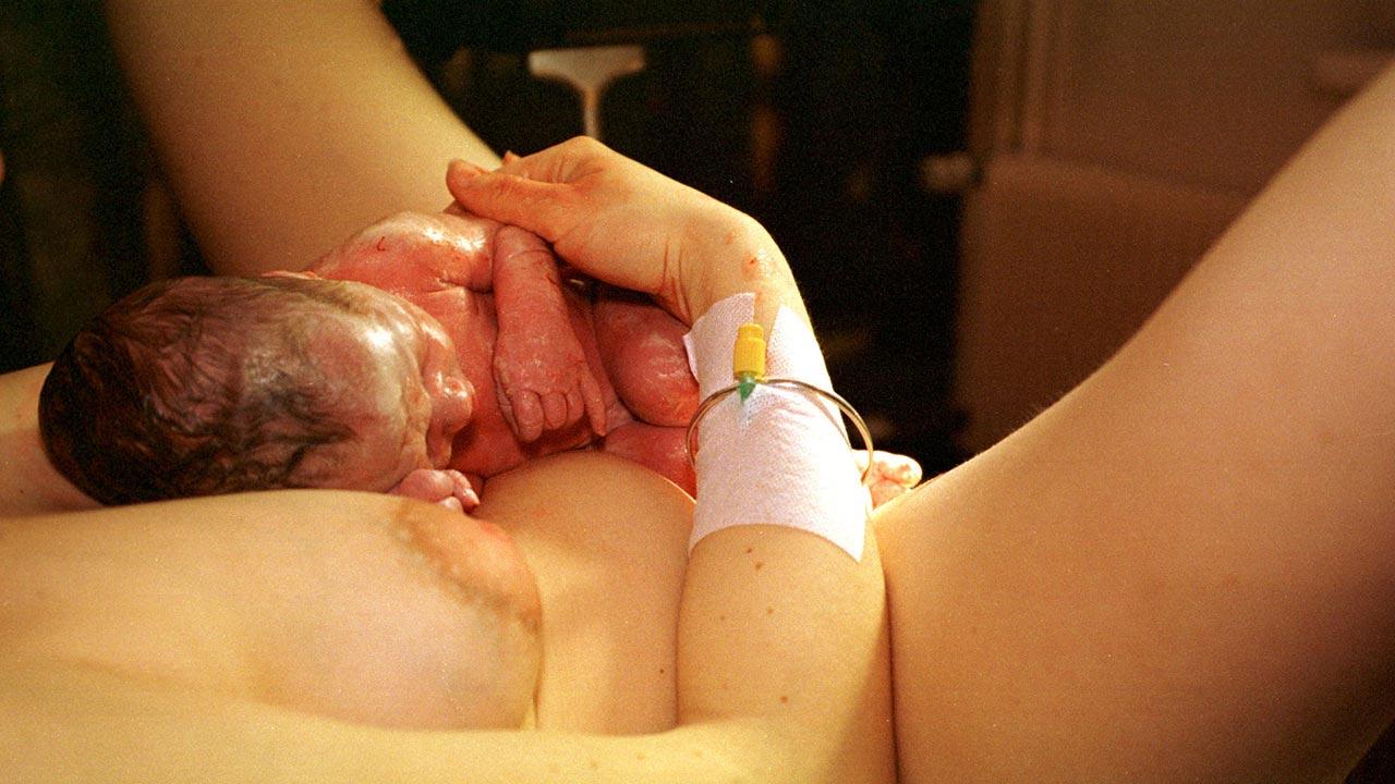 Nyfødt på maven af fødende kvinde