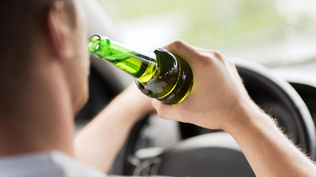 Mand drikker øl under kørsel i bil