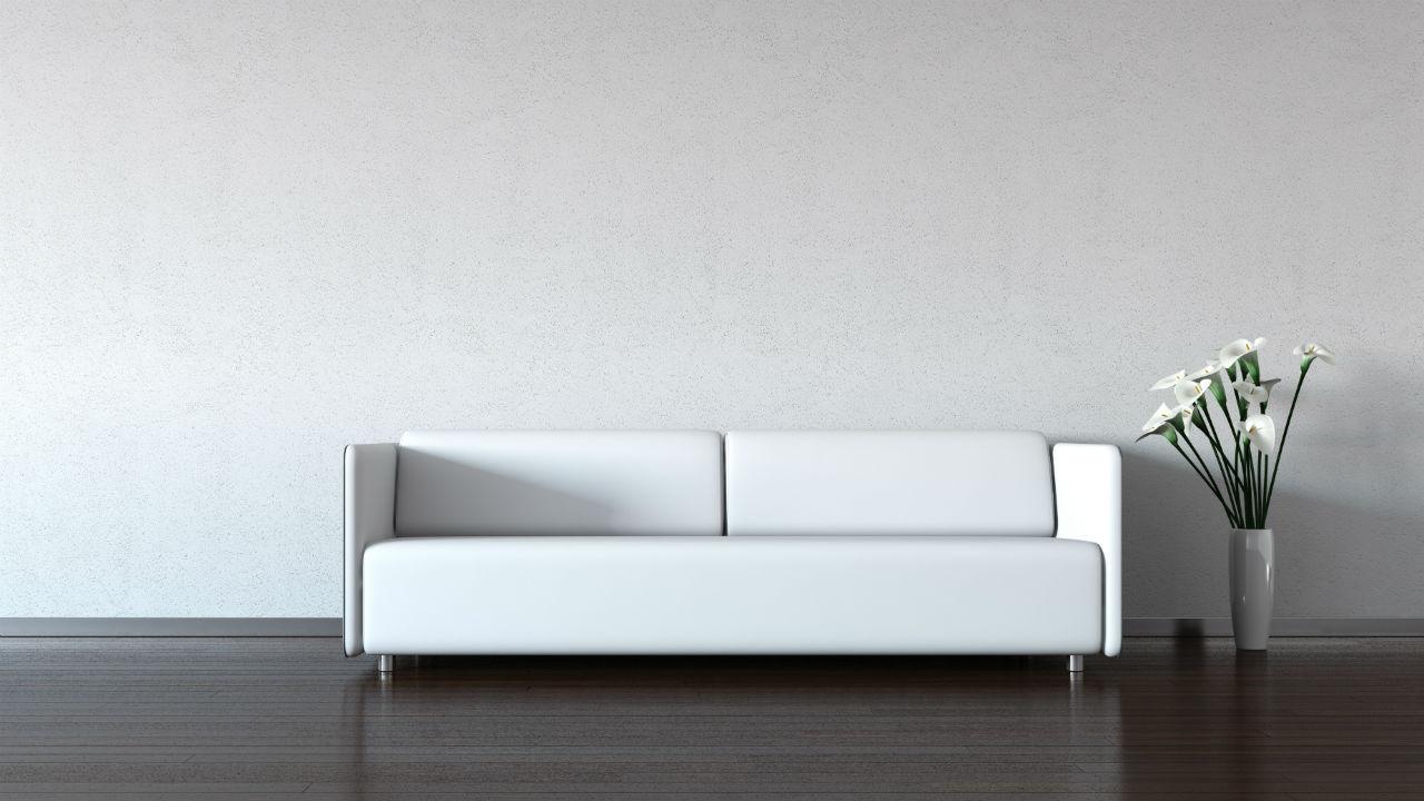 Hvid sofa op ad hvid væg. Intet pynt eller andre farver.